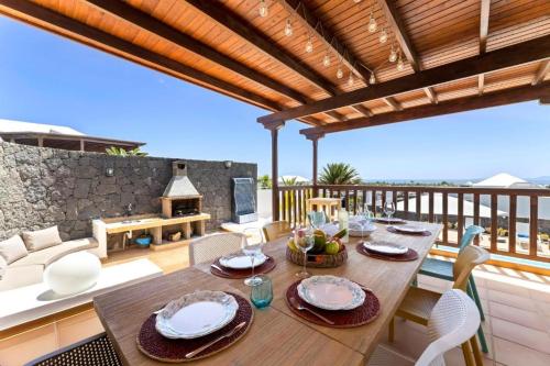 drewniany stół i krzesła na patio w obiekcie Lanzarote Villa Ascanio w mieście Playa Blanca
