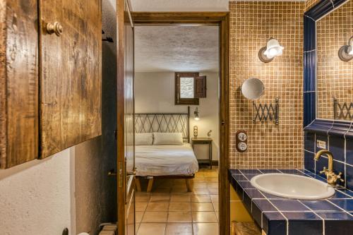 a bathroom with a sink and a bed in a room at Habitacions Mas Fuselles in Girona