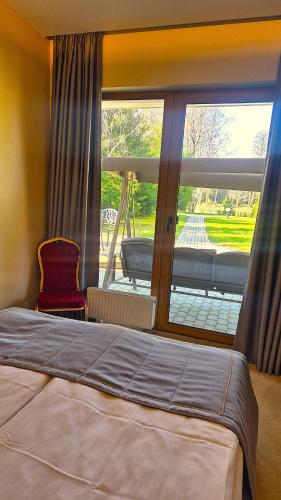 a bedroom with a bed and a large window at Atostogų būstas su jacuzzi in Klaipėda