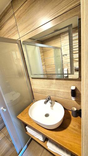 a bathroom with a sink and a mirror at Atostogų būstas su jacuzzi in Klaipėda