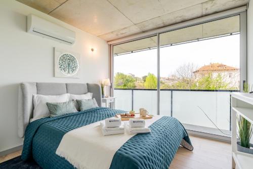 a bedroom with a bed and a large window at HostWise - Modern Flat w/ Balcony, Garage & Pool in Vila Nova de Gaia