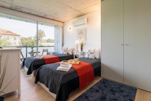 two beds in a room with a balcony at HostWise - Modern Flat w/ Balcony, Garage & Pool in Vila Nova de Gaia