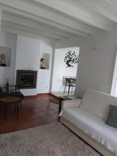 a living room with a white couch and a fireplace at Casa da Biquinha in Óbidos
