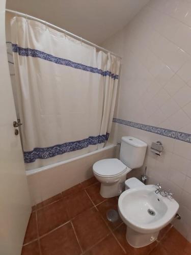 a bathroom with a toilet and a shower curtain at Casa da Biquinha in Óbidos
