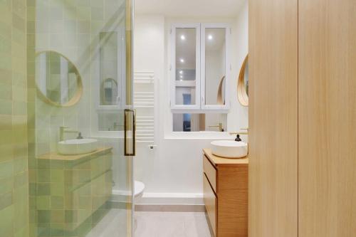 une salle de bain avec deux lavabos et une douche en verre dans l'établissement Peaceful Chic Studio - 2P - Parc Monceau, à Paris