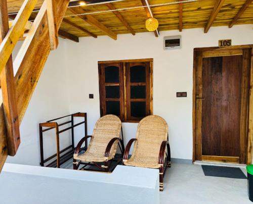 three wicker chairs sitting in the corner of a room at Beach Wave Hotel in Arugam Bay