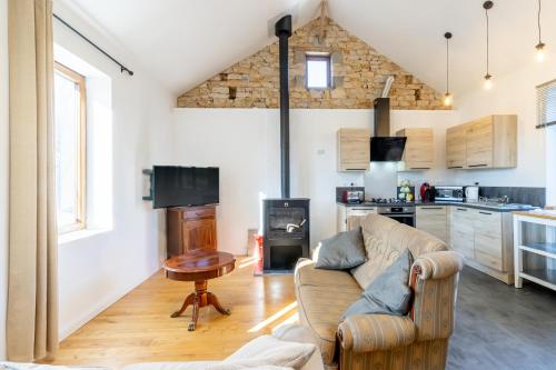 a living room with a couch and a table and a kitchen at Gite La Grange - Perigord Vert in Saint-Martial-dʼAlbarède