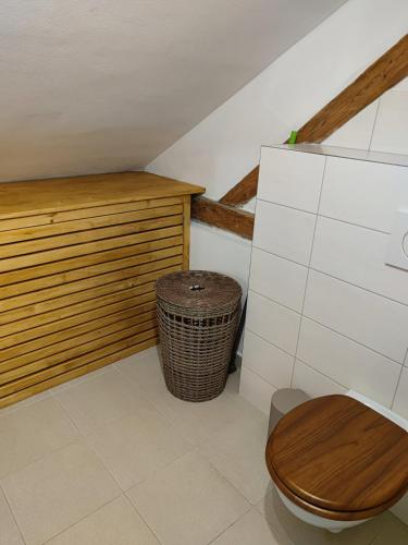 a bathroom with a wooden toilet and a trash can at Apartmán Červenka in Hartmanice