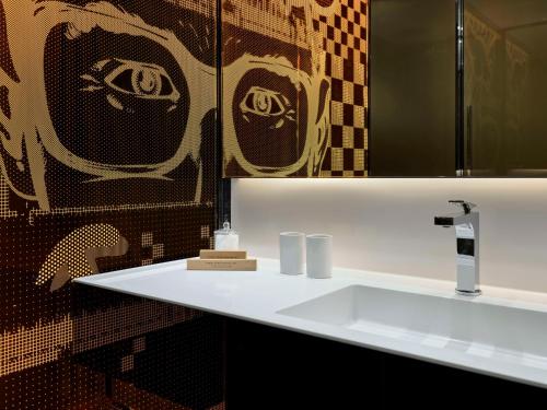 a bathroom with a white sink and a mirror at art'otel London Hoxton in London