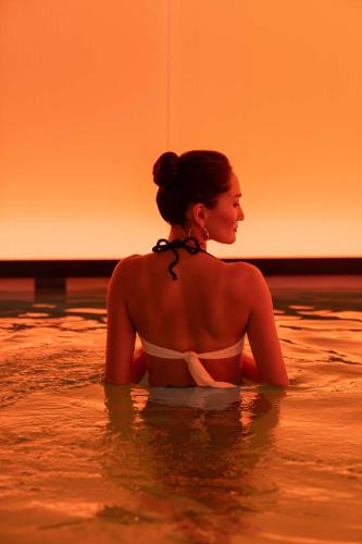 a woman sitting in the water in the ocean at art'otel London Hoxton in London
