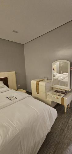 a hotel room with two beds and a mirror at Orchid Private Tourism Accommodation Facility اوركيد - لمرافق الضيافة السياحية الخاصة in Medina