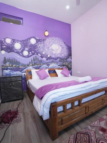 a bedroom with a large bed with a purple wall at The Van Allen Stays in Almora