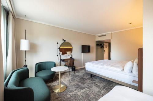 a hotel room with a bed and two chairs at Imperial Hotel in Copenhagen