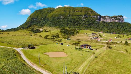 a field with a mountain in the background at Container da Montanha in Barracão