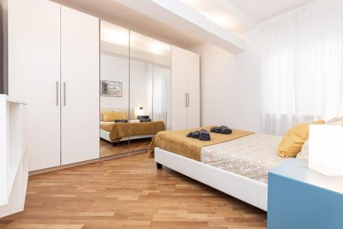 a white bedroom with two beds and a mirror at Centro Storico - Acquario di Genova in Genova