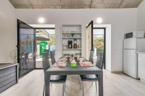 a dining room with a gray table and chairs at Home2Book Mountain Serenity House Agaete, Terrace in Agaete