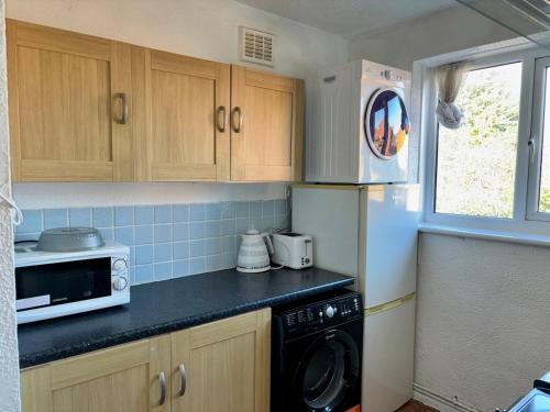 a kitchen with a refrigerator and a microwave at StanBros Side Flat in Coseley