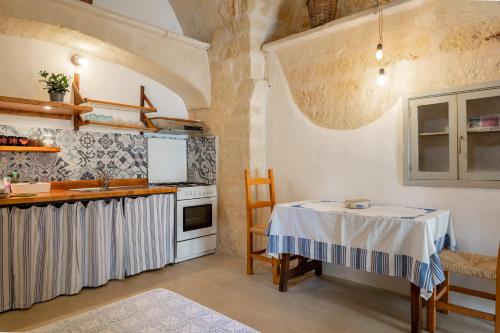 a kitchen with a table and a stove at La casa a corte con terrazzo - Artemisia Homes in Spongano