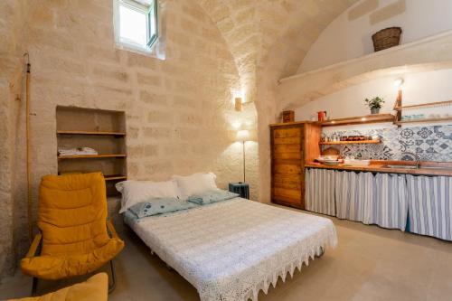 a bedroom with a bed and a chair in a room at La casa a corte con terrazzo - Artemisia Homes in Spongano