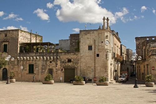 an old stone building with a car parked in a courtyard at La casa a corte con terrazzo - Artemisia Homes in Spongano