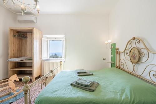 a bedroom with a green bed and a window at Bed and Breakfast Mea Familia in Vinci