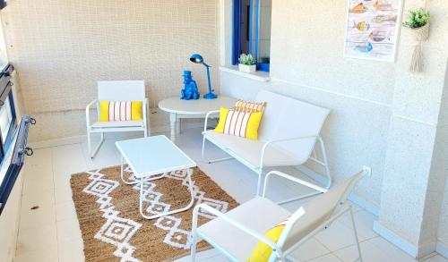 a patio with chairs and a table and a rug at Sea View Appartement Blue Monkey in Ifach