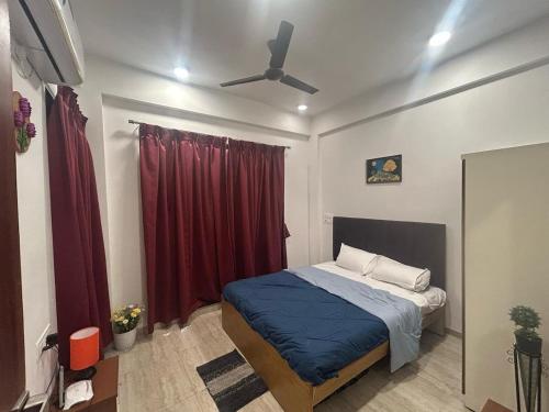 a bedroom with a bed and a red curtain at Dream House Villa in Wada