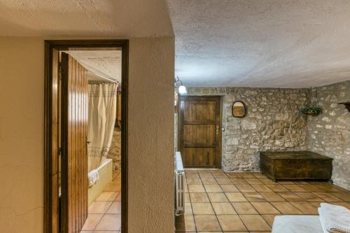 a room with a door and a stone wall at Habitacions Mas Fuselles in Girona