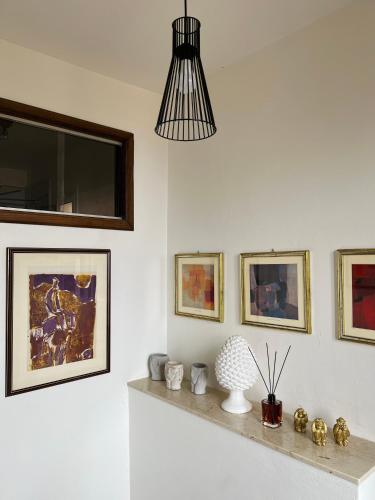 a room with white walls and a shelf with pictures at Tyche House Castelmola in Castelmola
