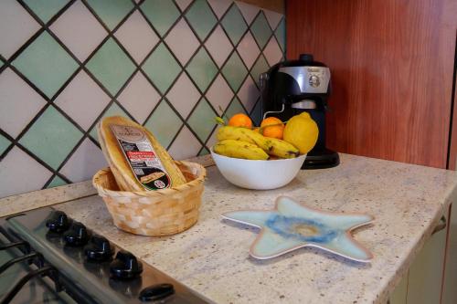 a bowl of fruit on a counter next to a starfish at Sardinianworld - Josto Panoramic House in S'archittu Cuglieri