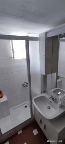 a white bathroom with a shower and a sink at Bike NIGHT-bike friendly, cozy loft, Finale Ligure in Finale Ligure