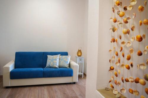 a blue couch in a living room with an orange wall at Sardinianworld - Josto Panoramic House in S'archittu Cuglieri