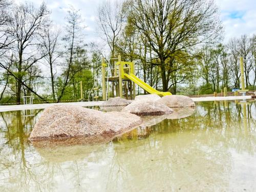 a playground with a slide in a pool of water at Vakantiepark de Witte Berg in Ootmarsum