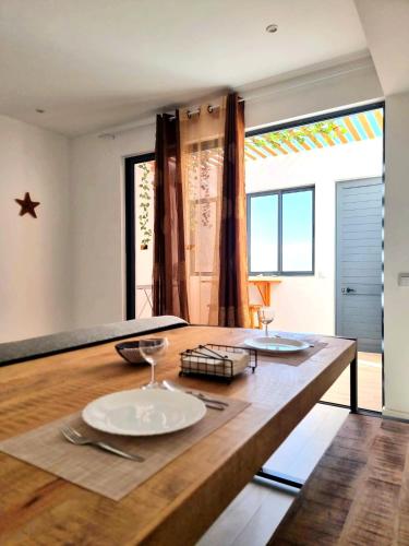 a kitchen with a wooden table with plates on it at R3 Apartments - Laginha in Mindelo