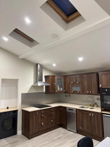 a kitchen with wooden cabinets and a stove top oven at Modern secure townhouse in Oldcastle