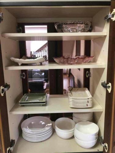 a cabinet filled with plates and bowls and dishes at Zamami Chura Dreamz in Zamami