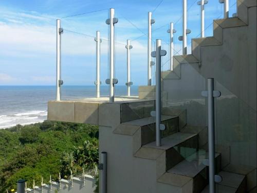 a staircase with a view of the ocean at Waves of Mercy in Trafalgar