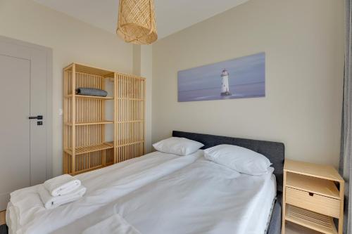 a bedroom with a large white bed with a lighthouse at GRANO FLATS - Sobieszewo - Baltic Porto in Gdańsk