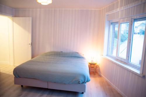a bedroom with a bed in a room with a window at Gaston vakantiehuis in Geraardsbergen