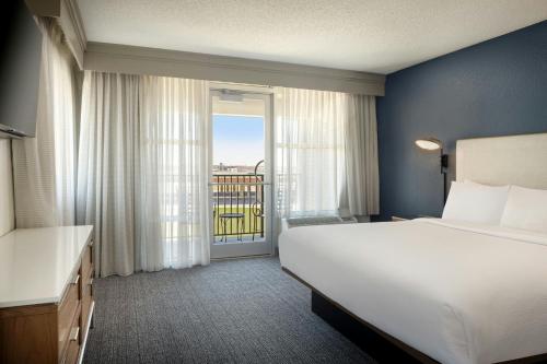 a bedroom with a large bed and a balcony at Courtyard by Marriott Little Rock Downtown in Little Rock