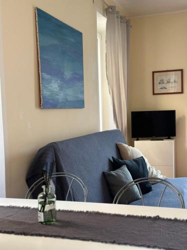 a living room with a blue couch and a television at Feriolo Nautique Apartments in Baveno