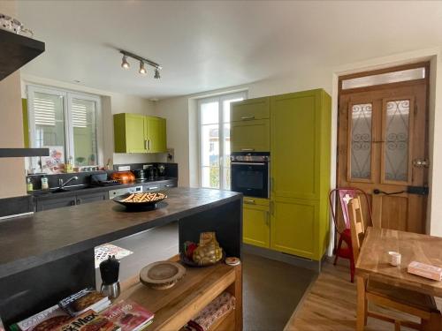 une cuisine avec des placards verts et une table en bois dans l'établissement Charming house in Concise, à Thonon-les-Bains