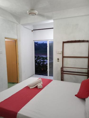 a bedroom with a large white bed with a window at Sadhara River View Lodge in Kandy