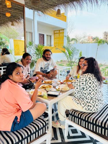 a group of people sitting at a table eating food at Hariom Tatsat Retreat in Pushkar