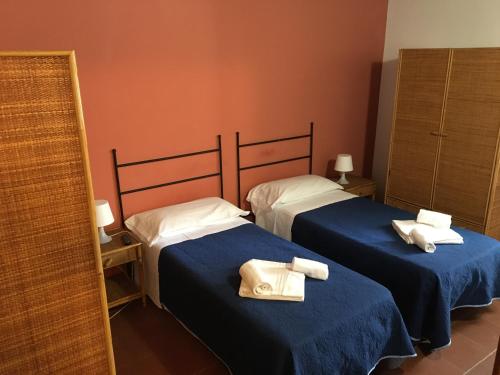 two beds in a room with towels on them at Terrasini 2000 Casa Vacanze in Terrasini