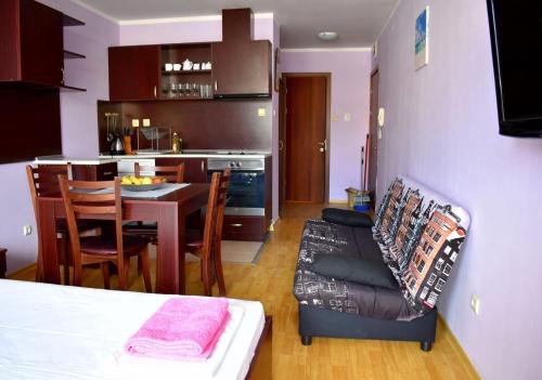 a room with a kitchen and a table and a couch at Julia Vigo Panorama apartments in Nesebar