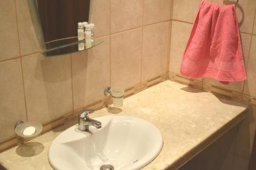 a bathroom with a sink and a red towel at Julia Vigo Panorama apartments in Nesebar