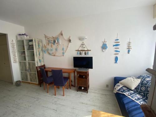 a living room with a table and a television at Claudia-Al Vittoriale in Gardone Riviera
