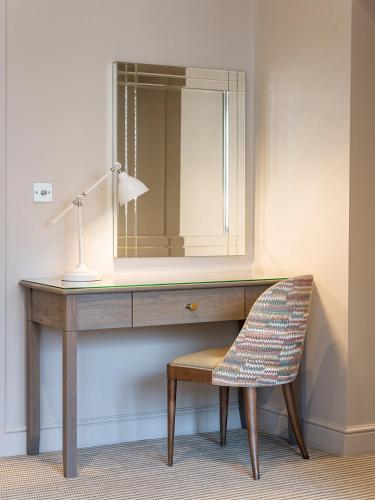 a dressing table with a chair and a mirror at The Kings Arms in Christchurch