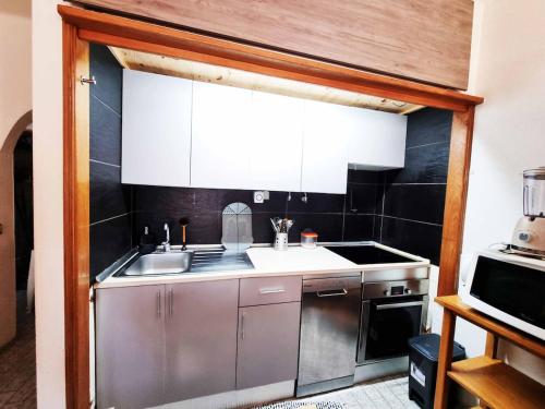 a small kitchen with a sink and a microwave at Sun & Fun in Armacao de Pera in Armação de Pêra